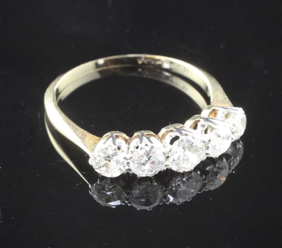 A mid 20th century 18ct gold and platinum five stone graduated diamond ring, size O.